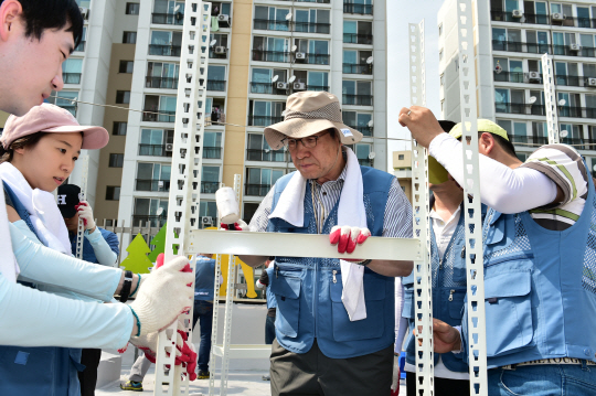 포스코는 '2016 포스코 글로벌 볼런티어 위크'를 맞아 서울 개포동 하상장애인복지관에서 봉사활동을 했다. 권오준 회장(가운데) 등 참여자들이 자체제작(DIY·Do It Yourself) 철재 가구를 조립하고 있다. <포스코 제공>